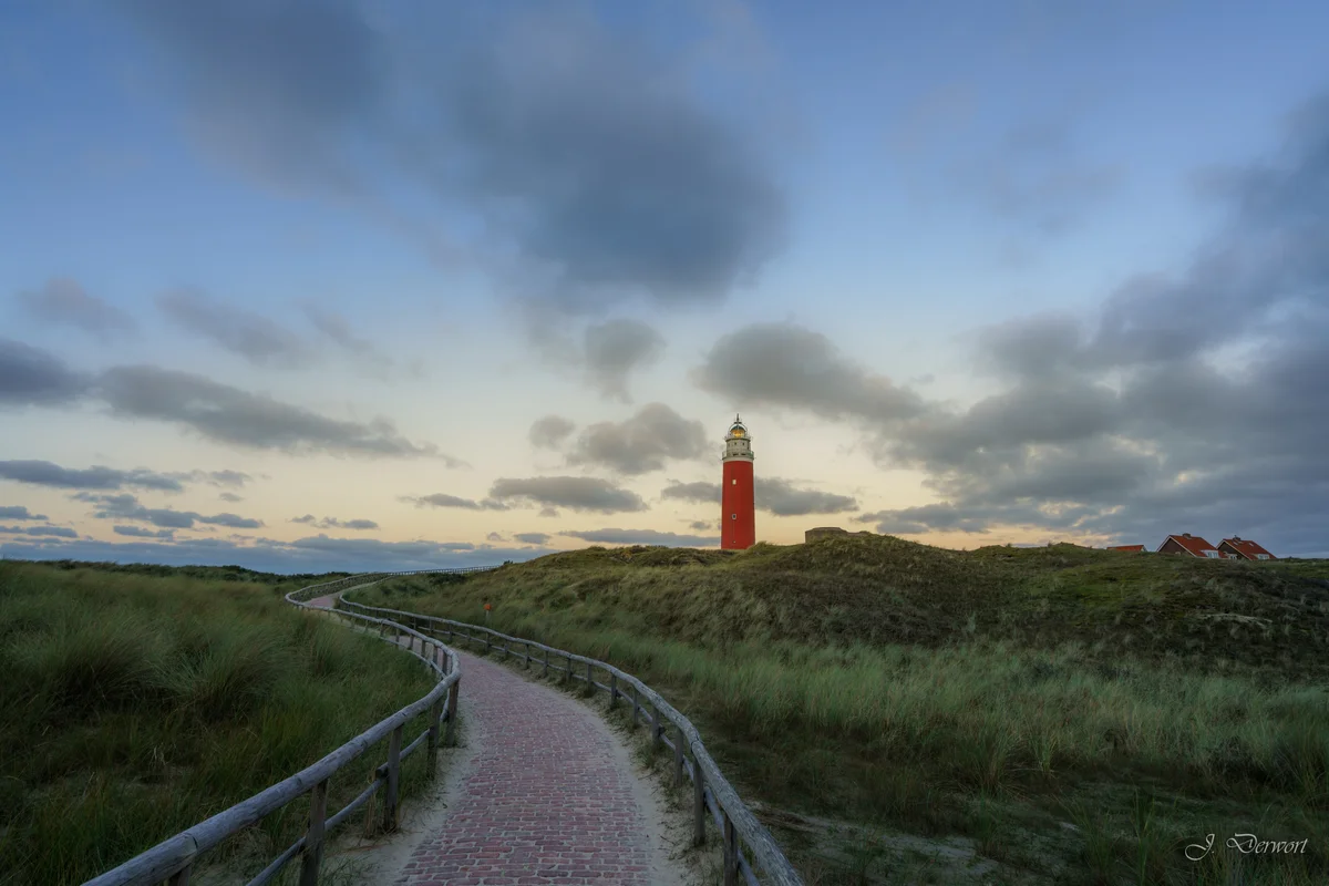 Red lighthouse rising above the coastal dunes of Texel